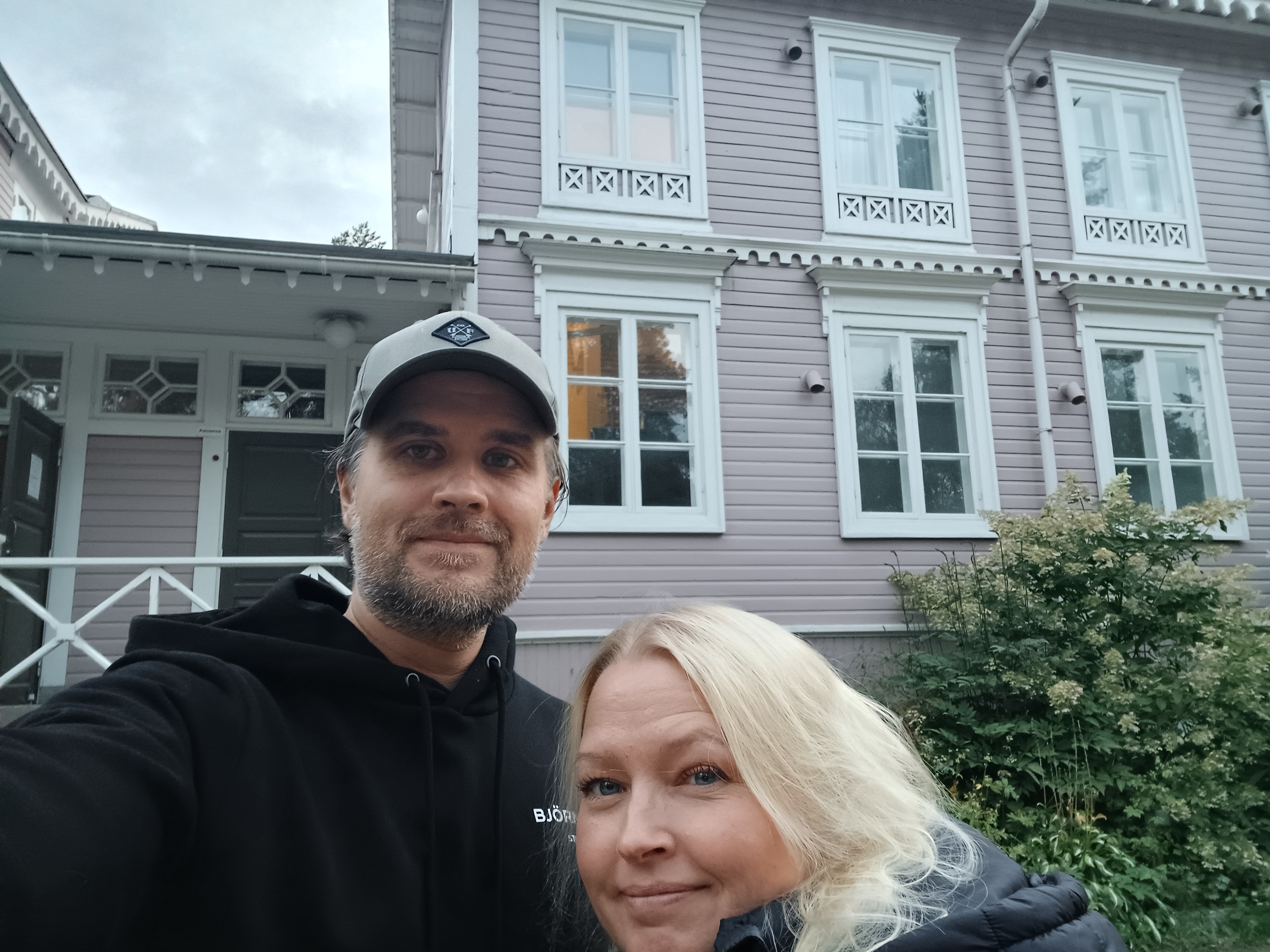 Meistä-sivun kuva rakennuksen edessä